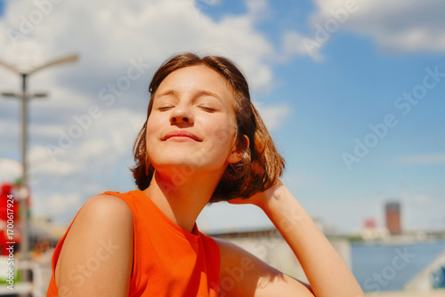 Wellness and self-care: gorgeous woman feeling summer sun warmth