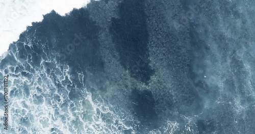 Flying above splashing waves in sea at daytime on sunlight. Power of ocean concept