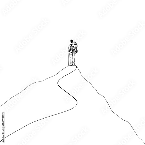 A lone hiker with a backpack standing atop a mountain peak looking out at the horizon in black and white style