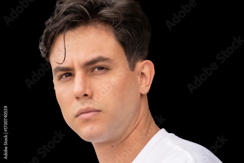 A man with short hair and a beard is looking at the camera