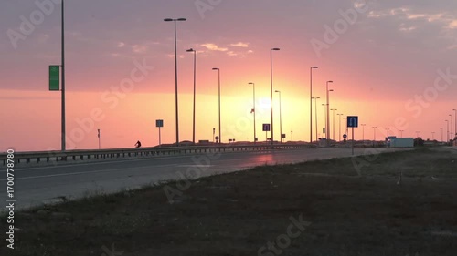 Time-lapse of sunrise against the backdrop of a highway.