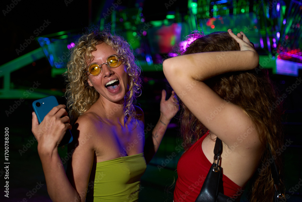 Naklejka premium Young women dancing and taking selfie at nightclub party