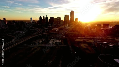 Aerial view of the dallas skyline at sunrise with the sun shining through the buildings