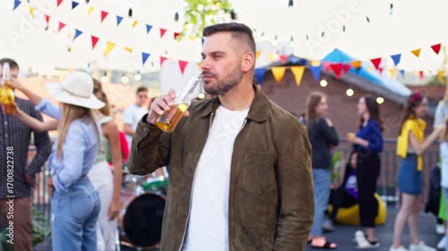 Wallpaper Mural Portrait of handsome cheerful young man holding and drinking beer. Attractive male smiling to camera having a good time with friends on party. Concert, roof party, fectival concept Torontodigital.ca
