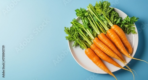 Freshly Harvested Carrots and Greens on a White Plate Against a Blue Background