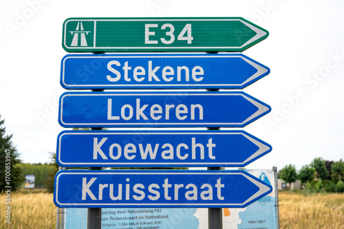 Road direction sign to the E 34 highway and cities nearby in Moerbeke, East Flanders, Belgium