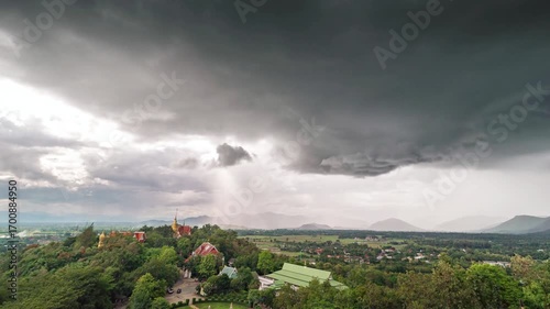 Storm cloud over the countryside with mountain and village in rainy season