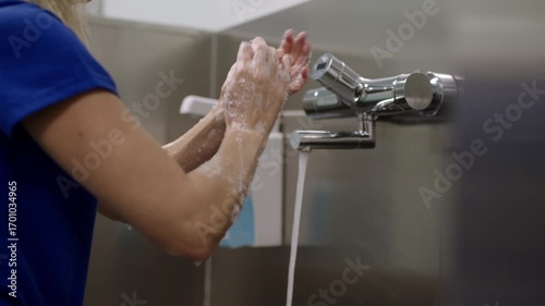 Medical professional washes hands under running water to promote hygiene.