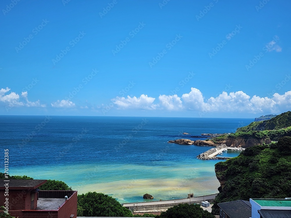 Fototapeta premium The Yin-Yang Sea in Ruifang, New Taipei City, Taiwan, is famous for its striking contrast of yellow-brown bay water and the deep blue ocean, caused by mineral deposits from the nearby Jinguashi mounta