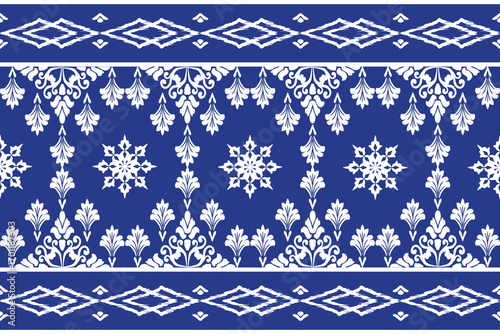 Motif ethnic ikat pattern seamless textile. Antique pattern, white flowers, navy blue background.