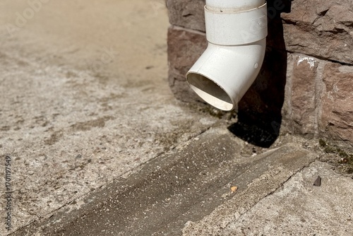 Wallpaper Mural Close-up of a weathered rainwater drainage pipe against a stone wall in an outdoor rustic setting Torontodigital.ca