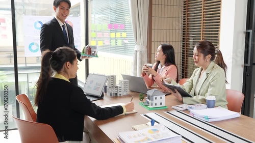 Asian real estate businessmen and home sales agents meet with clients and introduce new home models to Asian buyers investing in real estate business concepts.VDO Slow Motion