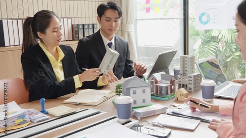 Asian real estate businessmen and home sales agents meet with clients and introduce new home models to Asian buyers investing in real estate business concepts.VDO Slow Motion