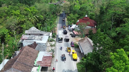 Aerial view of asphalt road repair with trial compaction process, testing surface quality before final paving. Infrastructure construction footage