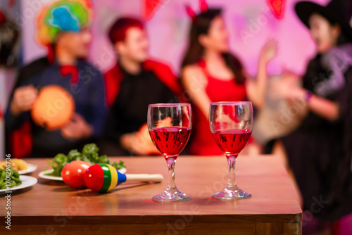 A lively Halloween party table featuring glowing pumpkin decor, festive food, and friends in costumes. celebration, creativity, and the joyful spirit of sharing spooky moments together.