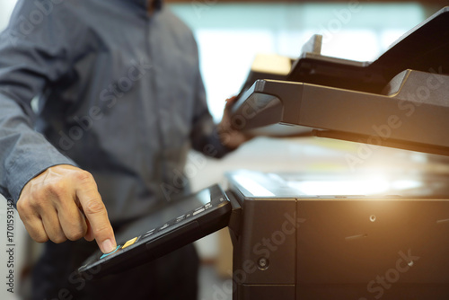 Photos Office men use photocopy or copier machine at workplace is equipment for make a copy paper or photocopier for scanning document and photocopying service maintenance concepts