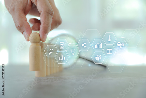 Hand chooses wooden person with HR human resources icons for personal leader training skill or leadership and challenge business team player and organization management teamwork.
