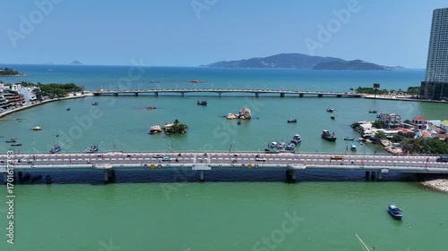Aerial view of Cau Xom Bong and Cau Tran Phu bridges across Cai river with boats and islands in Nha Trang city, Vietnam.
