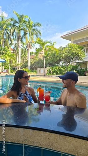 couple relaxing in the pool with drinks