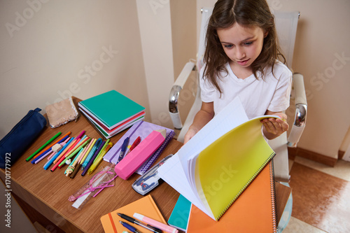 Young Girl Studying at a Desk with Colorful School Supplies