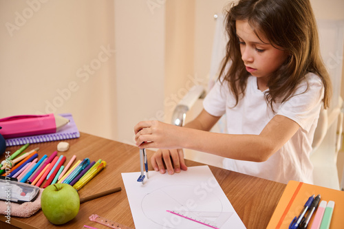 Young Girl Drawing a Circle Using a Compass on a Desk