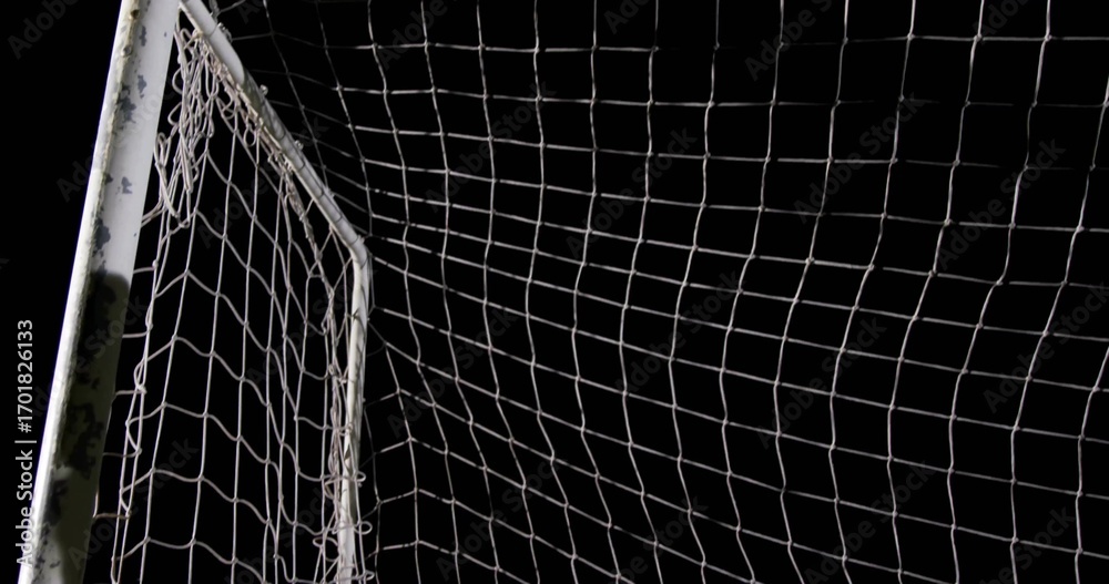 Fototapeta premium Framing white soccer goalpost with net standing on sports field at night, with chipped paint