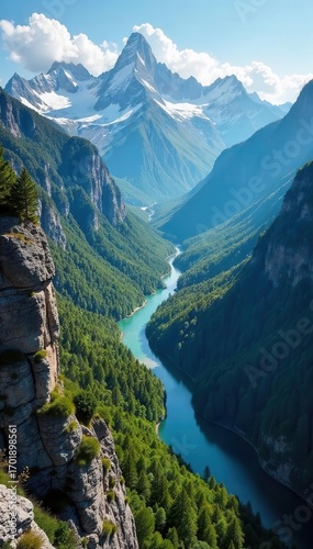 Snow capped mountains loom over a lush green valley with a winding blue river and rocky cliffs