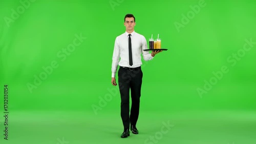 Dedicated Service: A poised waiter strides forward, balancing a tray laden with condiments against a vibrant green backdrop, embodying service excellence.