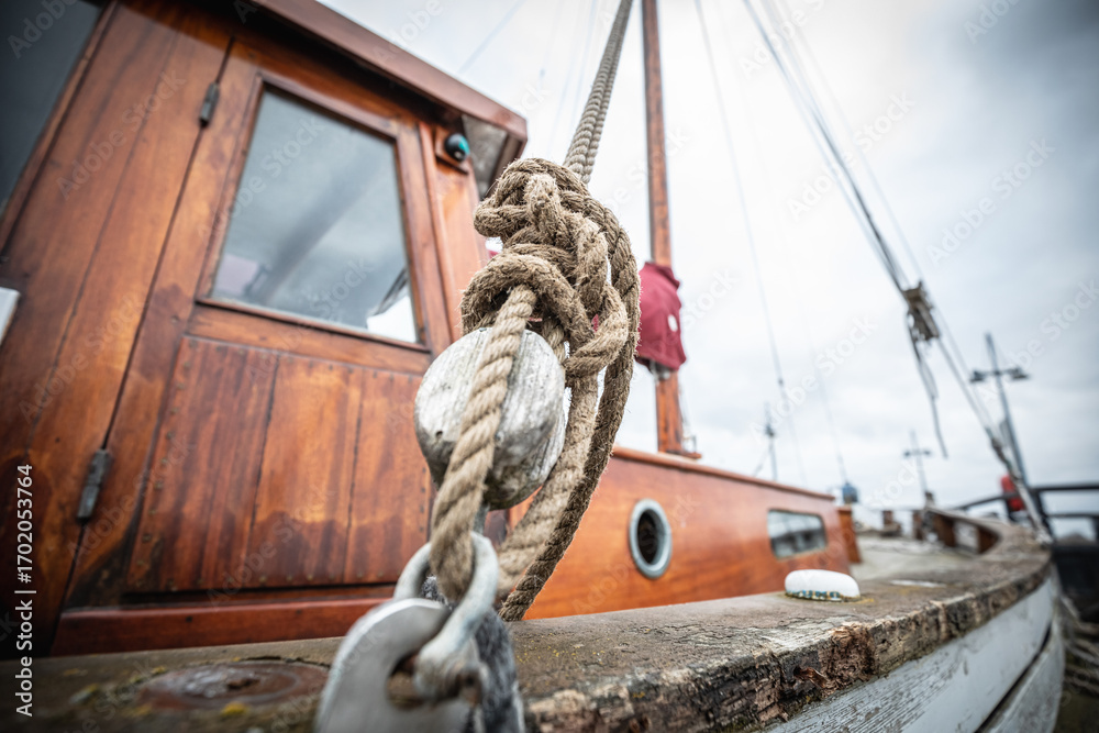 Obraz premium Artistic close-up of rope knot on fishing boat with mast in blur 