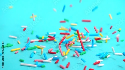 beautiful slow fall of bright sprinkles against tranquil blue backdrop, creating playful and charming scene for any project