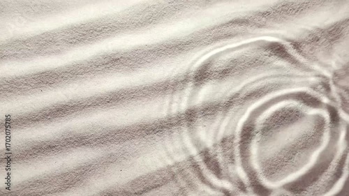 slow motion of drops cascading down onto sandy surface, creating tranquil ripples in water. Ideal for spa backgrounds and beauty product visualizations, copy space