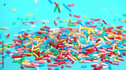 beautiful slow fall of bright sprinkles against tranquil blue backdrop, creating playful and charming scene for any project