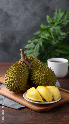 Durian fruit with yellow flesh and coffee on wooden table