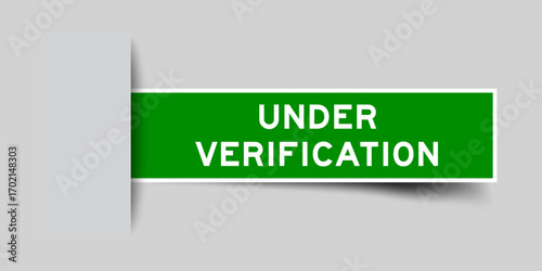 Green color square label sticker with word under verification that inserted in gray background