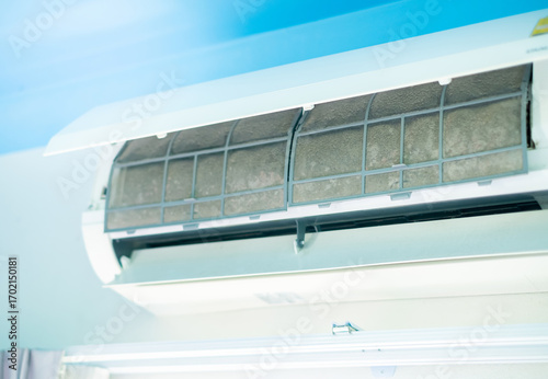 Dirty air conditioner filter covered with dust and debris inside indoor unit, showing poor maintenance and need for cleaning to improve airflow, energy efficiency, and healthy indoor environment.