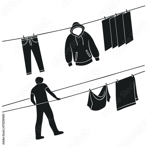 Silhouette of a person hanging laundry on a clothesline with jeans a hoodie and towels drying in the sun on a bright day