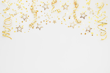 New Year, Christmas or birthday festive background top view. Celebration composition with golden confetti stars and serpentine party streamers.