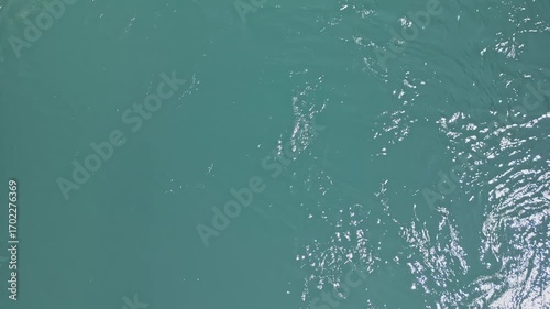 4k Aerial top down drone video of the Neretva River in Mostar, Bosnia and Herzegovina, showing its clear blue water flowing with gentle sunlight reflections during the day.