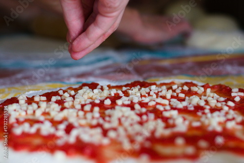 Hand Sprinkling Mozzarella Cheese on a Pizza