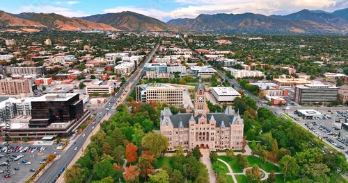 Flying over the Salt Lake City and County Building in Salt Lake City, Utah, USA. Beautiful mountain range at backdrop.