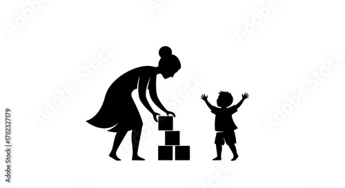 Silhouette of a mother building with blocks a tower for her child who happily watches with arms raised in anticipation of fun and play