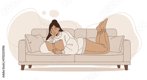 Woman relaxing on a sofa reading a book and enjoying her leisure time at home