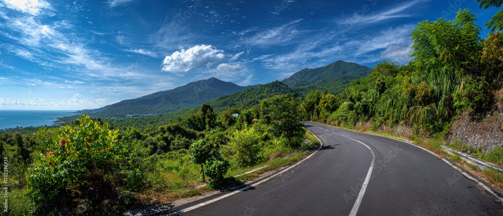 Obraz premium Winding coastal road through vibrant mountains and lush tropical landscapes invites exploration and adventure