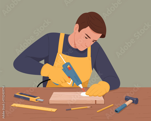 Man Engaged in Woodworking and Crafting Activity, Using Hot Glue for DIY Project on a Wooden Table