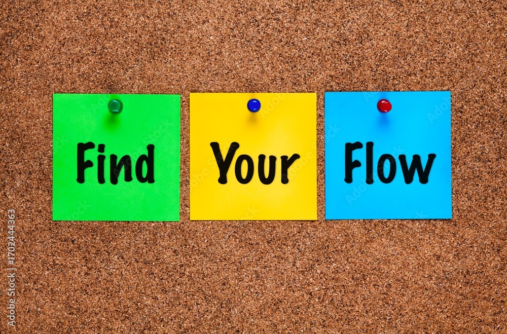 Three coloured paper notes with words Find Your Flow on a corkboard. Close-up