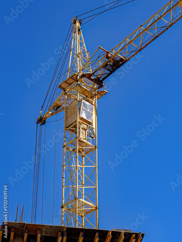 Wallpaper Mural Industrial construction crane towering against a blue sky Torontodigital.ca