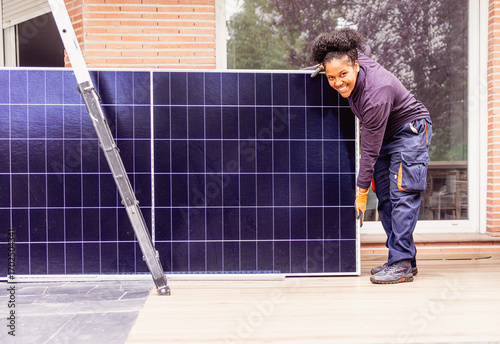 Papier peint Female worker preparing solar panels for installation on residential house roof