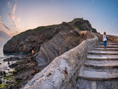 Ancient stone bridge leading to Gaztelugatxe islet at sunset Basque Country Spain symbol of journey solitude spirituality dramatic seascape inspiration