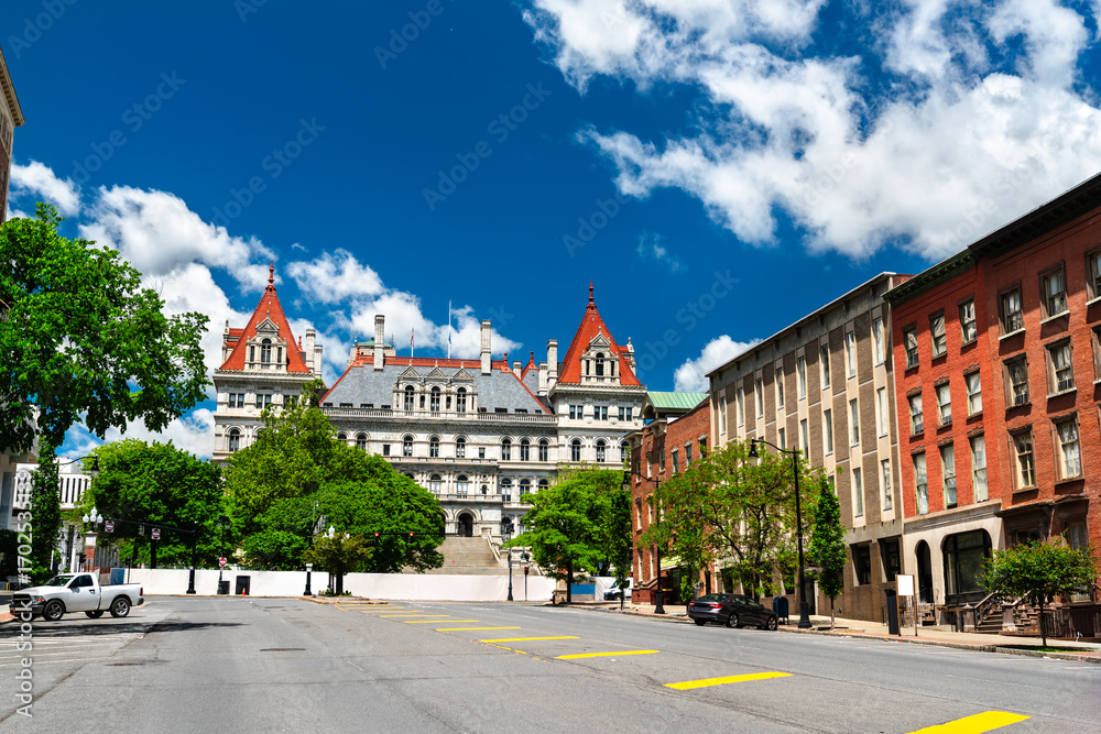 Obraz premium Street view of the historic New York State Capitol building, an architectural landmark in Albany USA, on a bright sunny day with a blue sky