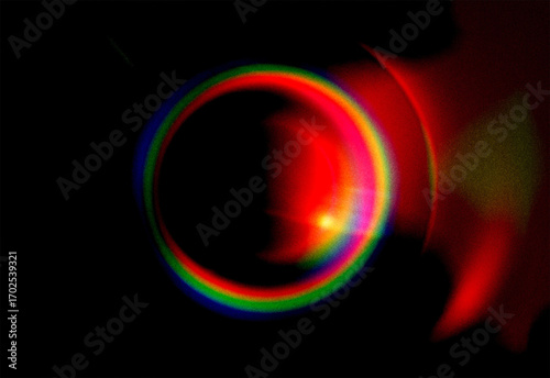 Vibrant glowing ring of spectral light creates an abstract prismatic effect, a futuristic optical phenomenon with lens flare on black